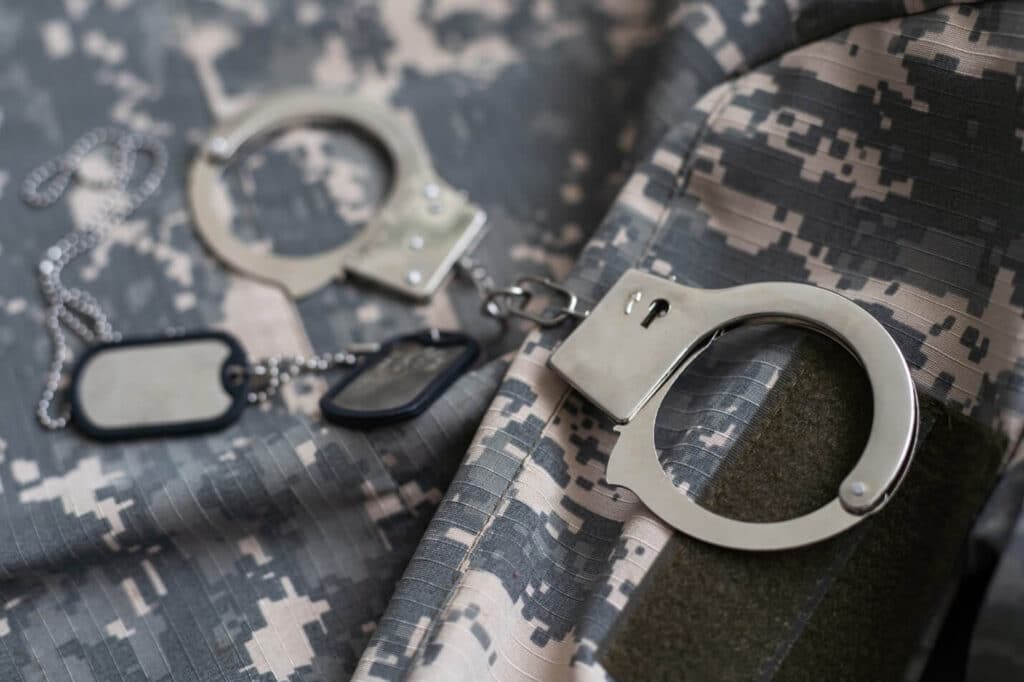 Close-up of handcuffs on a military uniform